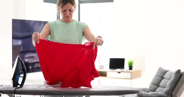 Γυναίκα Σιδερώνει Κόκκινο Μεταξωτό Πουκάμισο Σιδερώστρα Ρούχα Σιδερώματος Σιδερώστρα — Αρχείο Βίντεο