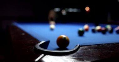 Oyuncu bilardo oynarken topa vuruyor. 4K film yavaş çekimde. Eğlence ve eğlence konsepti