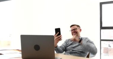 Mutlu iş adamı cep telefonuyla konuşuyor ve ofis 4K filminde iyi bir jest yapıyor. Ortaklar konseptiyle olumlu ruh hali ve dostça iletişim