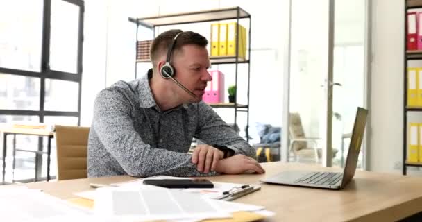 Грубий Агент Навушниках Мікрофоном Спілкується Через Екран Ноутбука Показує Середній — стокове відео