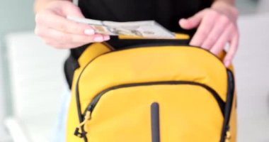 Kadın turist sarı sırt çantasına dolar koyar. Göçmenler, mülteciler ve sınır geçişleri