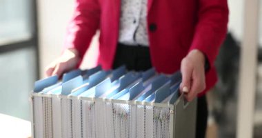 Sekreterin kadın elleri iş belgeleriyle dolu bir kutuyu tutuyor. Vergi alanındaki iş belgeleriyle çalış