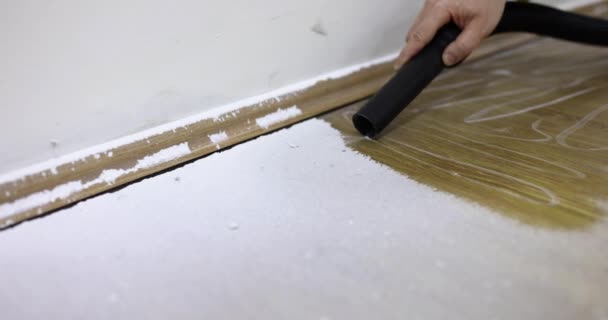 工業用コンクリートの塵やセメントの汚れから掃除機で床をきれいにします 木の床を掃除する労働者 — ストック動画