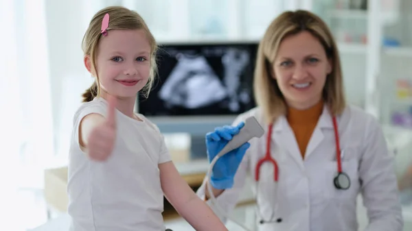 一个小女孩在看医生的时候带着超声波诊断法出现了大拇指 儿童概念中的高质量专业仪器体检 — 图库照片