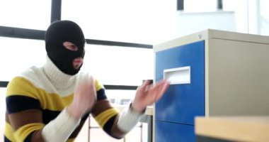 Yüzünde siyah maske olan zeki bir hırsız şarjörle kilidi açar. İsimsiz bir adam çekmecedeki değerli belgelerin olduğu dosyayı açıyor.