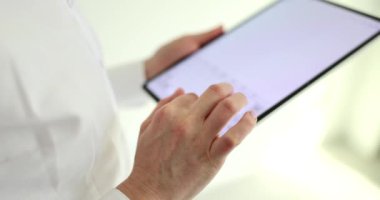 Beyaz gömlekli kadın çalışan, ofiste duran ortağına mesaj yazıyor. Kadın ağır çekim için modern elektronik cihaz kullanıyor.