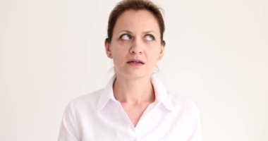 Şüpheli kadın başını yana çevirip bej arka planda geniş bir göz açıyor. Gergin kadın yeni alanı yavaş çekimde inceliyor.