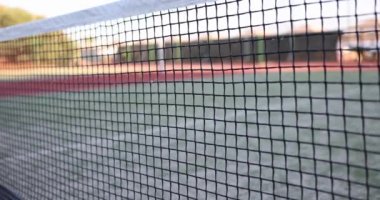 Yeşil oyun kortuna takılmış sarı tenis topuna isabet etti. Oyuncu golü kaybediyor. Çocuk parkında spor müsabakası yavaş çekimde