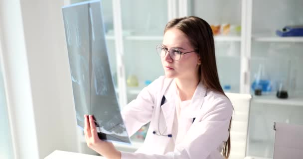 Médico Concentrado Estuda Imagem Radiológica Coluna Vertebral Paciente Sentado Mesa — Vídeo de Stock