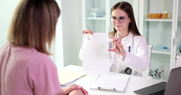 Positive Arzt Gibt Behandlungsplan Und Flasche Pillen Frau Tisch Sitzen — Stockvideo