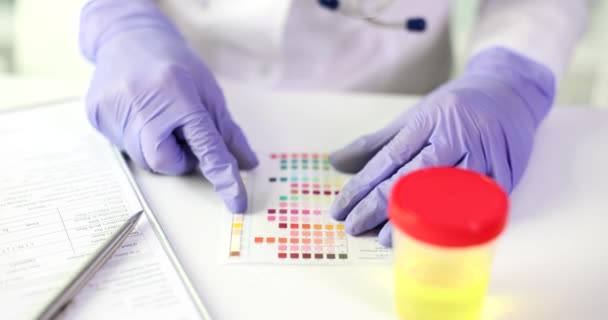 尿样检测后 化验室工作人员将色泽与试剂纸进行对比 女人在黄色液体慢动作容器附近做研究 — 图库视频影像