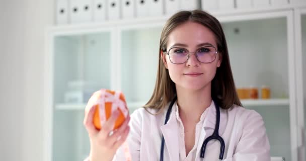 Pozytywny Dietetyk Trzyma Świeżą Pomarańczę Owiniętą Taśmą Kamerą Specjalista Zaleca — Wideo stockowe