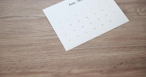 女性は木のテーブルの上に月のカレンダーと紙シートをスローします 女性従業員は オフィススローモーションで作業スケジュールを作成する準備 — ストック動画
