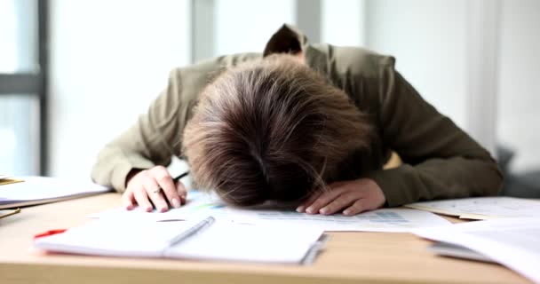 過労の女が散乱調査紙でテーブルの上に頭を打つ 疲れ秘書は オフィススローモーションで書類作成を行うに退屈感じています — ストック動画
