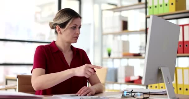 Kafası Karışık Bir Kadın Ofiste Otururken Izlemek Için Parmağıyla Işaret — Stok video