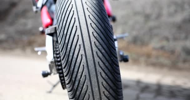 黑色橡胶轮胎的大摩托车车轮在模糊的背景 停在乡间地面路上的摩托车很笨重 车辆的详细部分 — 图库视频影像