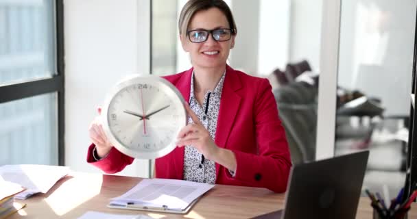 Positive Female Employee Glasses Holds Wall Clock Hands Looking Camera — Stock Video
