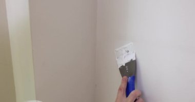 Foreman duvardaki delinmiş delikleri macunla dolduruyor. Uzman duvardaki hasarı karşılıyor. Daireyi yavaş çekimde yenileme işlemi