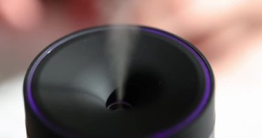 Yayıcı gerekli yağları yayar ve odadaki havayı nemlendirir. Modern nemlendirici, aroma su parçacıklarını bulanık arka planda havaya dağıtır.