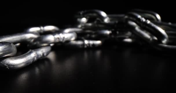 长长的铁链在深色桌子表面反射 为Bijouterie设计的Shiny链环 黑底宏观钢制设备 — 图库视频影像