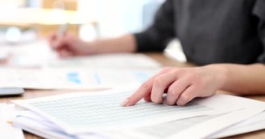 Sekreter, soruşturma belgelerindeki notları kontrol ediyor. Ofiste masa başında evrak işleriyle uğraşan bir kadın. Çalışan istatistiklerle çalışır