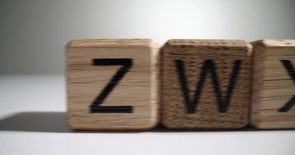 Dřevěné Bloky Anglickými Písmeny Stojí Dlouhé Řadě Náhodně Bílém Povrchu — Stock video