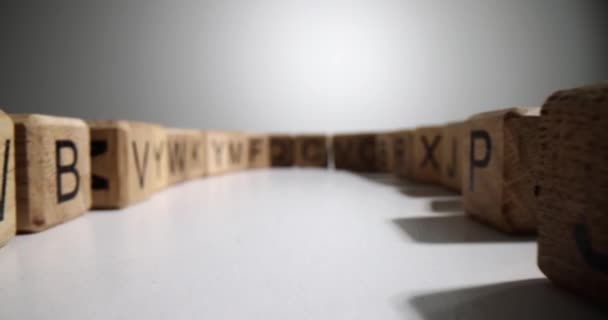 Holzwürfel Mit Englischen Buchstaben Stehen Geschwungener Reihe Auf Weißer Tischfläche — Stockvideo