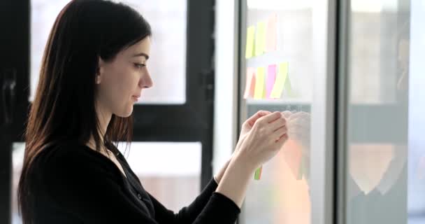 Concentrated Woman Places Sticky Notes Business Ideas Whiteboard Young Brunette — Stock Video
