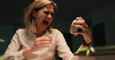 Korku içindeki iş kadını alarma bakıyor ve gece geç saatlerde gök gürültüsü 4K filmi sırasında ofis masasında bağırıyor. Geç saatlere kadar çalışıp son otobüs konseptini kaçıracağım.