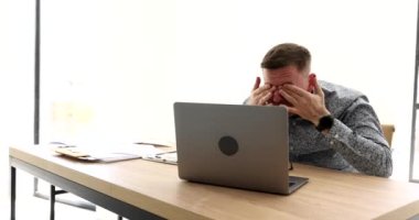 Gözlüklü bir iş adamı dizüstü bilgisayar 4K filminde gözlerini kısarak bağırıyor. Kötü iş haberleri çevrimiçi kavramı