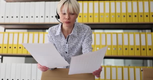 Bizneswoman Słuchawkach Mikrofonem Studiuje Dokumenty Biznesowe Konferencja Poświęcona Pracy Zdalnej — Wideo stockowe