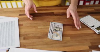 Kadın ofisteki masaya dolar yatırıyor. Mali yatırım ve nakit kazanç