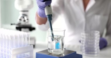 Termostat sensörlü manyetik karıştırıcı bilim adamı su örnekleri alıyor. Laboratuvarda sıvı deneylerinin bileşimi üzerine çalışıyorum.