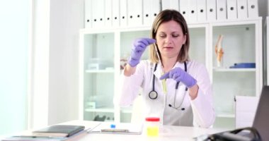 Doktor ya da hemşire laboratuarda test bantları ve idrar tüpleri tutuyor. Zehirli sıvıların idrar analizi ya da incelenmesi
