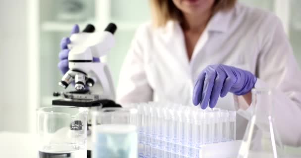 研究者は実験室の試験管に見える 法医学微生物学生化学遺伝学 — ストック動画