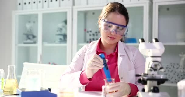 化验室密闭中带有测试仪和黄色液体的化学家科学家 尿液或油类产品分析 — 图库视频影像