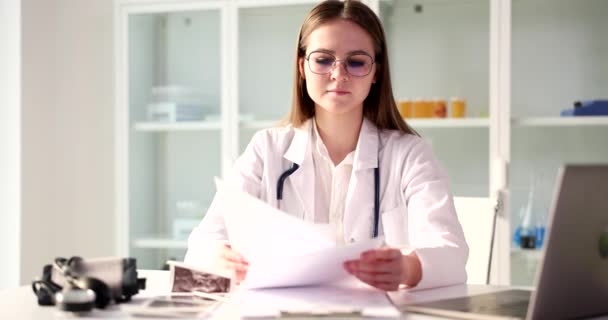 Konzentrierter Seriöser Allgemeinmediziner Der Die Krankengeschichte Des Patienten Liest Aufzeichnungen — Stockvideo