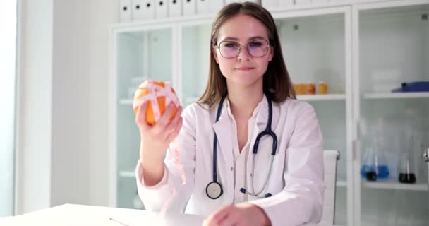 栄養士の医師はオレンジと測定テープを保持します 食事と健康的な食事 — ストック動画