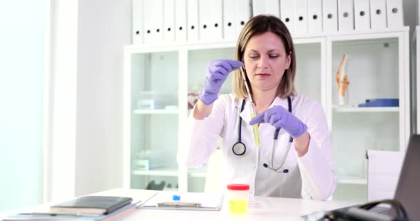 医生或护士在实验室里拿着带尿液的试纸和试管 尿液透析或有毒液体检查 — 图库视频影像
