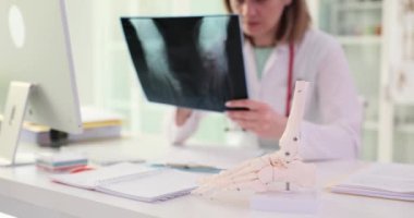 Doktor ayak röntgeni ve bacak kemiklerinin anatomisini tutuyor. Travmatolog klinikteki ayak röntgenine bakıyor.