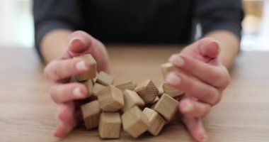 Kadın elleri masaya tahta küpleri döker. Yaratıcı çözümler bulmak hedef ve motivasyon kavramı