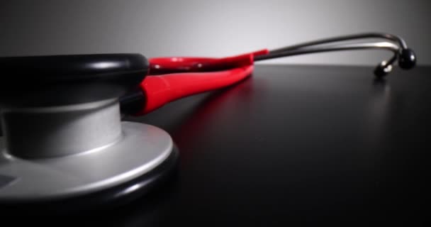 黒の背景に赤い医療用聴診器 致命的な疾患および死亡率の診断 — ストック動画