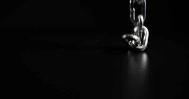 バックライト付きの黒の背景に金属チェーン 鉄鋼金属鉄鎖と家庭内暴力 — ストック動画