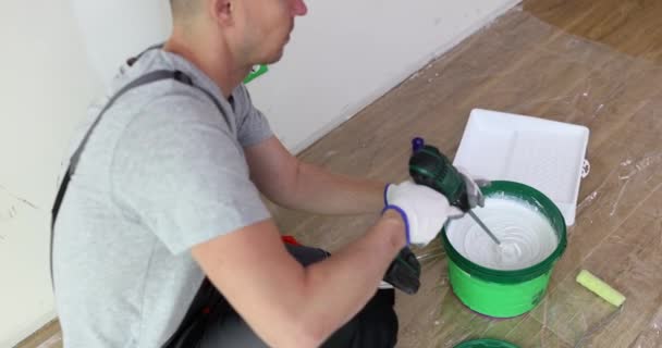 Εργαζόμενος Αναμιγνύει Λευκή Μπογιά Κουβά Χρησιμοποιώντας Μίξερ Σύρμα Ζωγράφος Σπίτι — Αρχείο Βίντεο