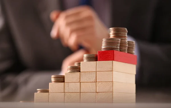 stock image Wooden blocks with coins growing stacked and stacked in increasing piles. Investment growth and financial profit concept