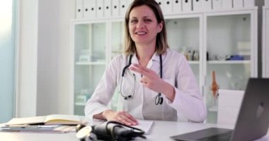 Gülümseyen bir doktor baş parmağının hareketini gösterir, yakın plan. Klinikte başarılı tıbbi prosedürler