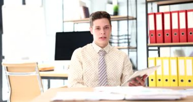 Genç bir iş adamı masada oturduğunu söylüyor, yakın plan. Ofiste kariyer, satış müdürü, sığ odak