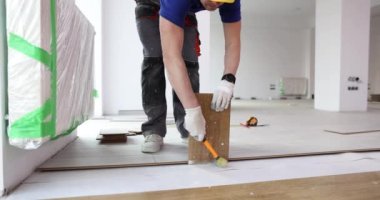 Üstat yere kaplama döşemiş, yakın plan. Evdeki zemin kaplamalı güncelleme, yavaş çekim