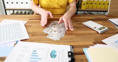 Ofisteki kadın masadaki dolarları sayıyor, yakın plan. Maaş ve ikramiye çalışanı, yavaş çekim