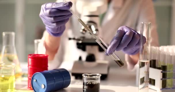 研究室のアシスタントは フラスコ クローズアップに黒い液体を注ぎます 燃料の化学的検査 — ストック動画